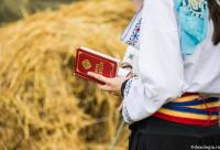 femeie în costum popular cu Micul Ceaslov în mână