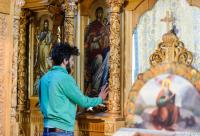 tânăr în fața icoanei Maicii Domnului
