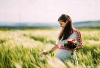 femeie cu buchet de flori în mână în lan