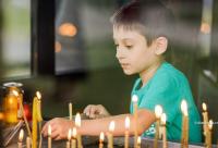 copil aprinzând lumânări