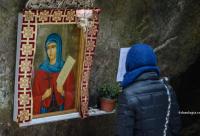 femeie în fața icoanei Sfintei Teodora