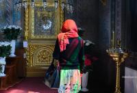 femeie în fața icoanei Maicii Domnului