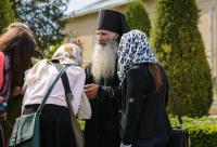 preot binecuvântând un grup de credincioși