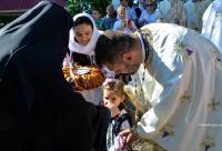 copilă sărutând Sfânta Cruce