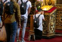 tânăr în genunchi în fața iconostasului