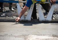 muncitor finisând placa de beton