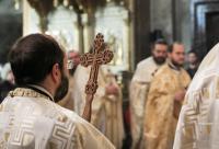 preot cu crucea în mână