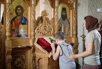 copil închinându-se la icoană