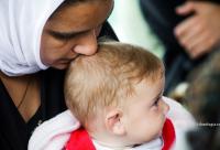 mamă sărutând creștetul copilului