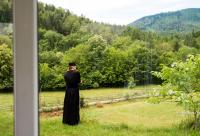 călugăr privind în curtea mănăstirii