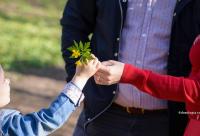 copil care daruieste flori mamei