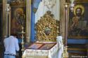 bărbat în fața icoanei Maicii Domnului