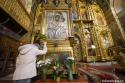 femeie în genunchi în fața icoanei Maicii Domnului