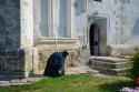 călugăr închinându-se în timp ce bate toaca mică
