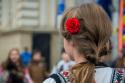 fată în costum popular cu floare roșie în păr
