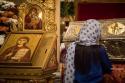 femeie rugându-se la racla Sfintei Cuvioase Parascheva