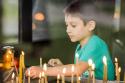 băiat aprinzând lumânări