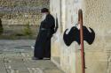 călugăr sprijinit de zidurile bisericii
