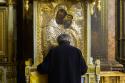 bărbat în fața icoanei Maicii Domnului