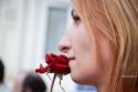 femeie mirosind trandafirul